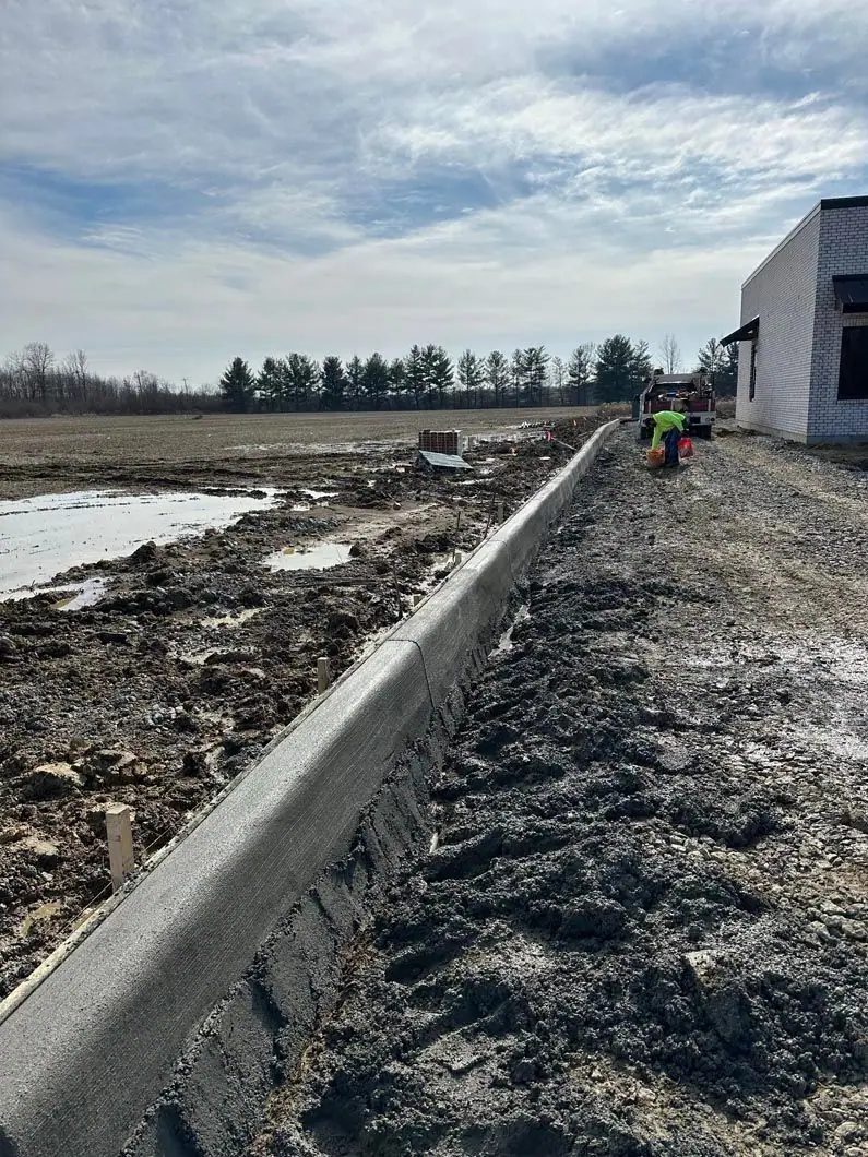 Concrete curb formed beside a compacted gravel base
