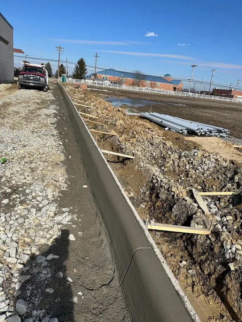 Formed concrete curb with cones marking the work zone