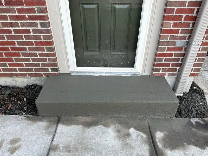 New concrete step at a brick home entry
