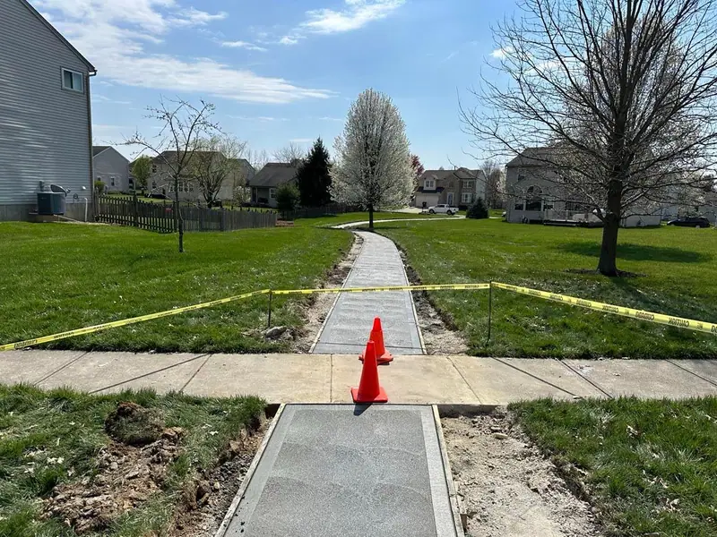 New concrete sidewalk connection with cones and caution tape