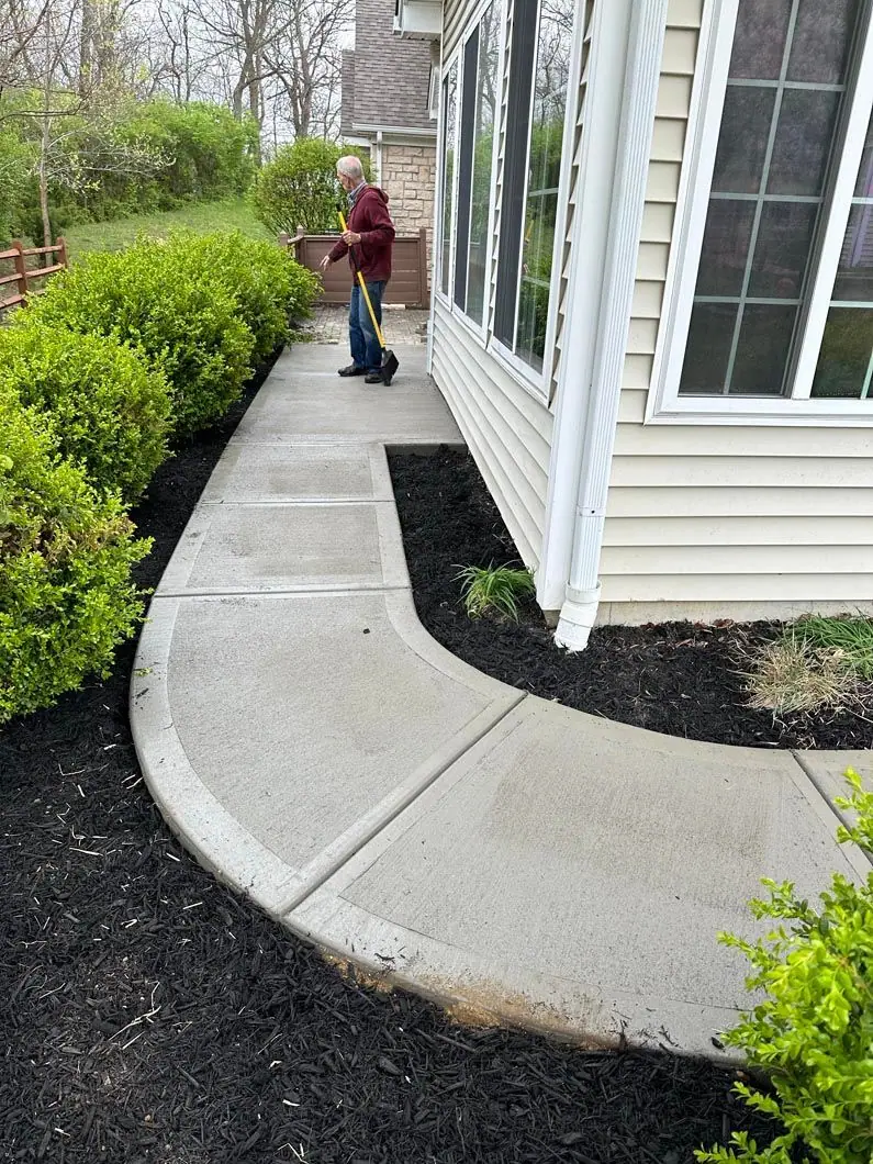 Curved concrete walkway alongside landscaped beds
